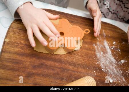 Child using cutting to make gingerbread men Stock Photo