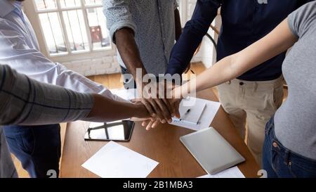 Closeup diverse employees put hands in stack showing support Stock Photo