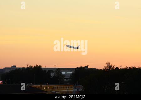 Airplane taking off in sunset Stock Photo