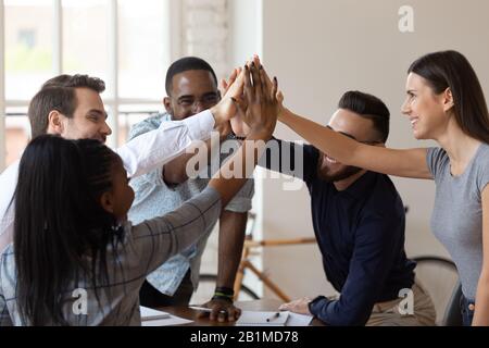 Excited multinational employees celebrating team victory giving high ...