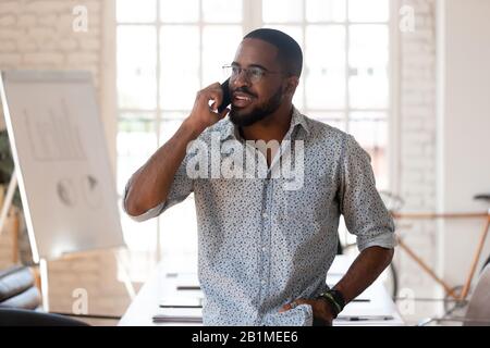 African businessman talking on phone inside of modern office Stock Photo