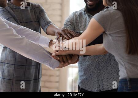 Diverse businesspeople stacking hands together engaged in team building Stock Photo