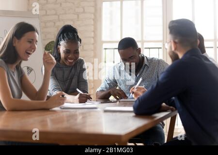 Employees take break during meeting having fun telling jokes laughing Stock Photo
