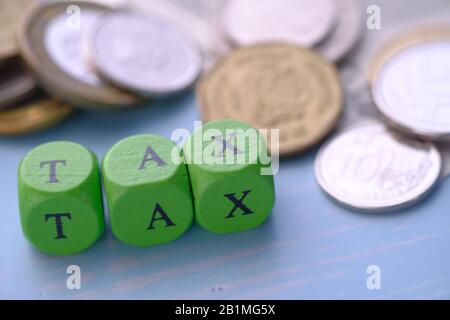 tax concept with coin and letter wooden block on table  Stock Photo