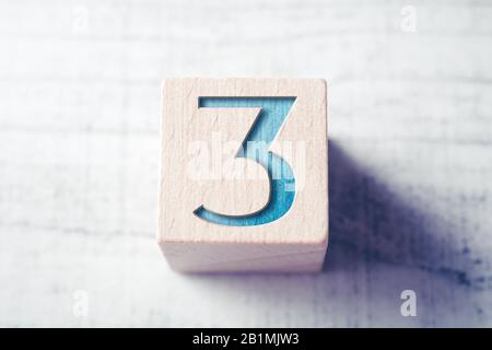 Number 3 On A Wooden Block On A Table Stock Photo