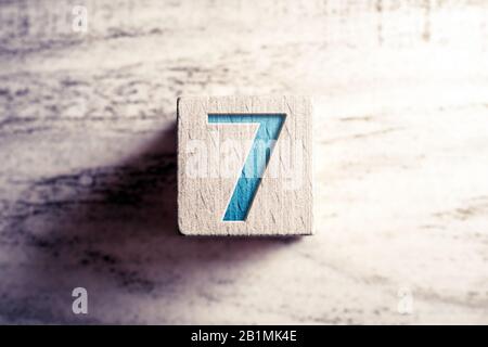 Number 7 On A Wooden Block On A Table Stock Photo