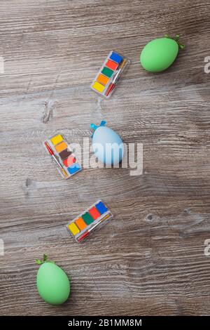 easter eggs and colorful paints and brushes on wooden background. Beginning to painting. Copy space Stock Photo