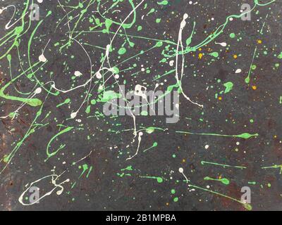 Splashes of colored paint on a black surface. Stock Photo