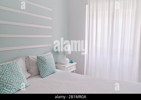 Shabby style mint pastel bedroom. Cozy bedroom with large window Stock Photo