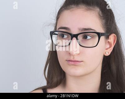 Portrait of a Serious Bespectacled Long-haired Brunette Teen Girl Stock Photo