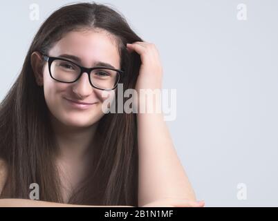 Portrait of a Smiling Bespectacled Long-haired Brunette Teen Girl Stock Photo