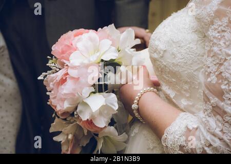 A brides flower bouquet being held by a bride on her wedding day Stock Photo