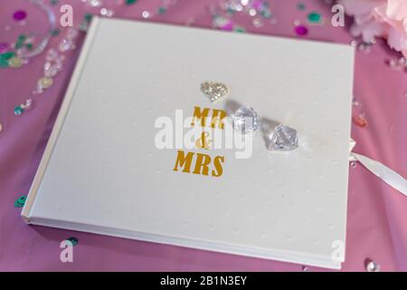 a wedding guest book with Mr and Mrs written on the cover surrounded by glitter and decoration, used for wedding guests to sign Stock Photo