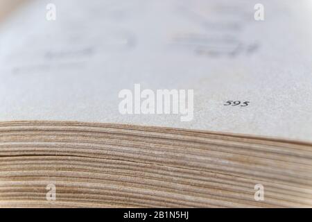 Macro image of yellow images of old, big book turned on page 595 Stock Photo
