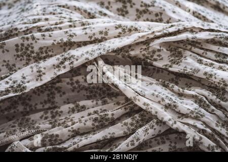 Detail of a crumpled shawl of fabric in ivory color with green tiny flowers Stock Photo