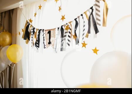 eco-friendly fabric garland for a holiday with the number one in yellow and black and a bunch of colored balls on the sides, a card for the first birt Stock Photo