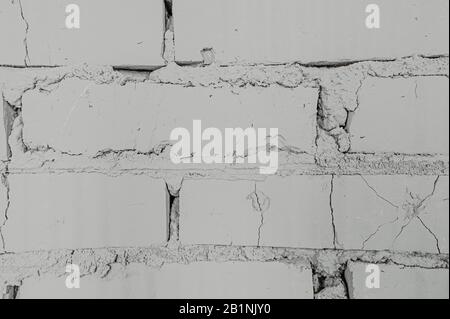 homogeneous background clean white brick wall with cracks from old age Stock Photo