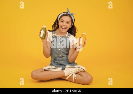 Lead a healthy life through nutritious eating and physical activity. Happy small girl hold bottles with healthy nutrition. Little child enjoy healthy lifestyle. Healthy diet for kids. Stock Photo