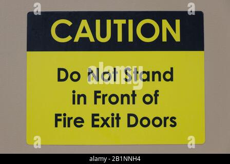 'Caution: Do not stand in front of Fire Exit Doors' warning text and sign inform to keep the doorway accessible Stock Photo