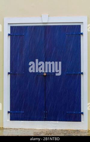 Caribbean shop door, Under lock and key, Blue door with white trim, virgin islands weathered architecture, locked wooden door, padlocked building Stock Photo