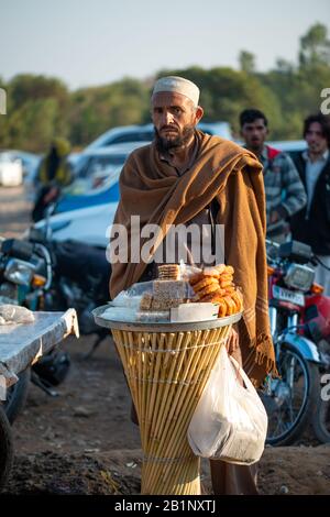 Islamabad, Islamabad Capital Territory, Pakistan - February 05, 2020, An old man selling home mades traditional sweets on the street in Islamabad, Stock Photo