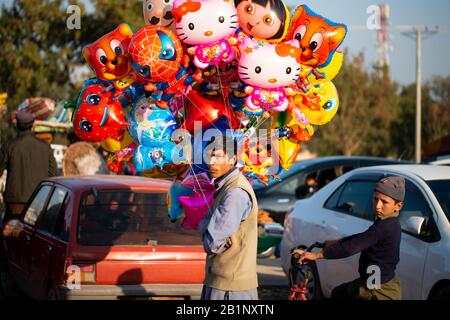 Islamabad, Islamabad Capital Territory, Pakistan - February 5, 2020, A man on a street selling colourful helium balloons. Stock Photo
