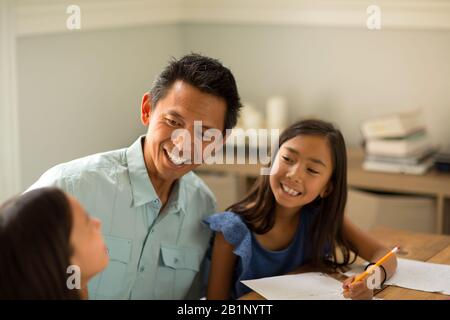 Mother Helping Her Daughters With Their Homework Stock Photo