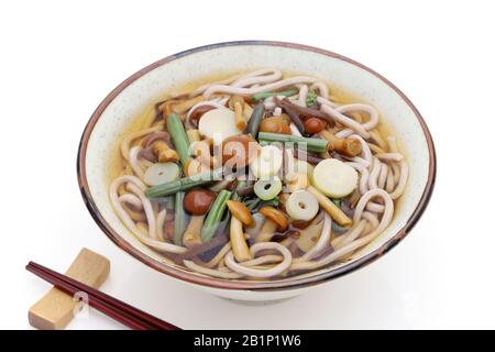 Japanese Sansai soba noodles in a ceramic bowl with chopsticks on white background Stock Photo
