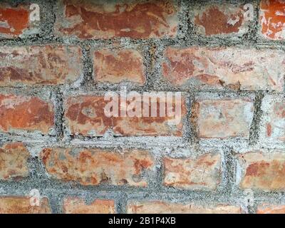 Abstract pattern of an old red, orange and black brick wall with lots of texture useful for backgrounds and wallpapers. Stone Wall Texture. Stock Photo