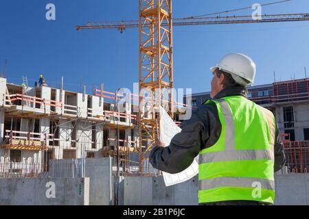 architect engineer worker on construction site checking plan drawing Stock Photo