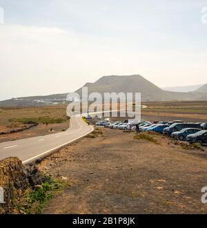 Tourists cars parked along an open road showing the landscape of Lanzarote Island Canary Islands Spain Stock Photo