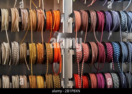 Stand with coils of multicolored textile braided cables Stock Photo