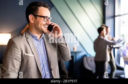 Young handsome businessman using smartphone in the office Stock Photo