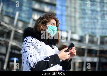 Milan, Italy. 26th Feb, 2020. A woman wears a face mask in Milan, Italy, Feb. 26, 2020. A total of 400 people have tested positive for the novel coronavirus in Italy till Wednesday evening. The government has placed 11 towns, 10 in Lombardy and one in Veneto, under lockdown in an effort to contain the epidemic. Credit: Daniele Mascolo/Xinhua/Alamy Live News Stock Photo