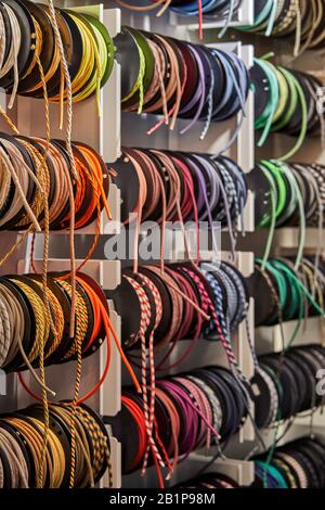 Stand with coils of multicolored textile braided cables Stock Photo