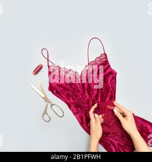 The process of manually sewing linen. Scissors, accessories for sewing. Lace in the hands of a tailor close-up. The apartment was lying. Square format Stock Photo