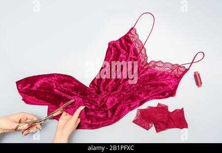 The process of manually sewing linen. Accessories for sewing. Scissors in the hands of a tailor close-up. The apartment was lying. Copy space. Flat la Stock Photo