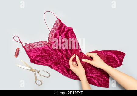 The process of manually sewing linen. Scissors, accessories for sewing. Lace in the hands of a tailor close-up. The apartment was lying. Copy space Stock Photo