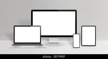 Responsive design devices mockup. Laptop, computer display, phone and tablet with isolated screen on work desk Stock Photo