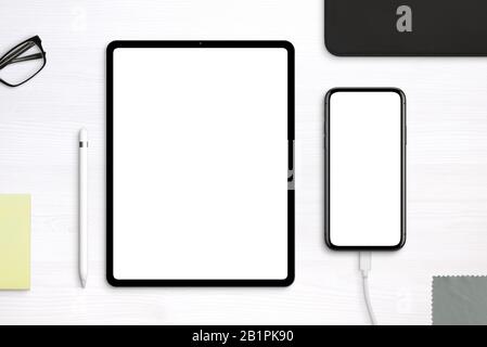 Tablet and phone mockup on desk. Top view, flat lay scene with separated layers Stock Photo