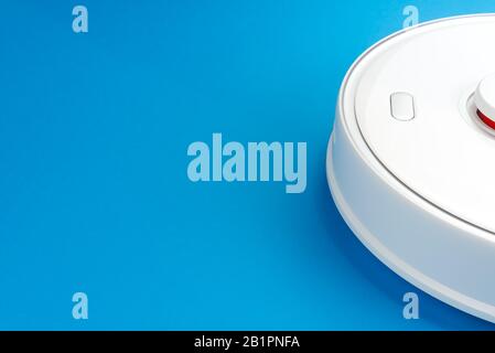 White robotic vacuum cleaner isolated on blue background Stock Photo