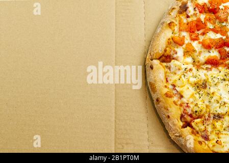Flat lay of tasty italian pizza on on cardboard box. Cheese and peppers. Delicious food. photo can be used for pizzeria menu Stock Photo