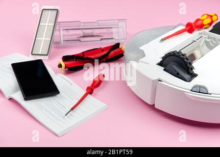 white robot vacuum cleaner. Vacuum cleaner robot repair concept on pink background. technology robot Stock Photo