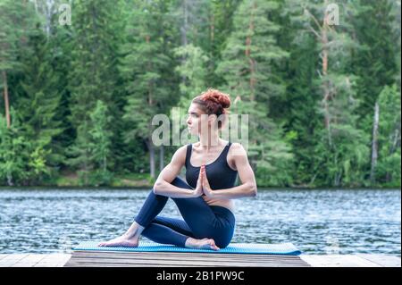 Half Lord of the Fishes Pose or Ardha Matsyendrasana performed by a  caucasian young man on the colorful mat by wearing black attire Stock Photo  - Alamy
