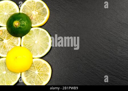 Top view of lemon and lime on black plate with black background Stock Photo