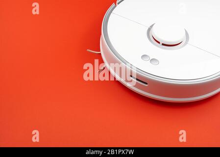 robot vacuum cleaner isolated on red background, close up photo. close up photo Stock Photo