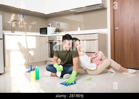 Young happy Asian couple is having fun while doing cleaning at home. Stock Photo