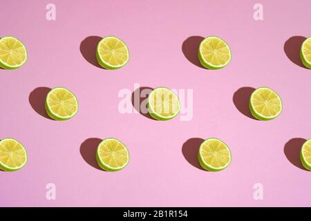 Pattern of lime citrus fruit slices on pink background, creative design seamless texture, abstract food photography Stock Photo