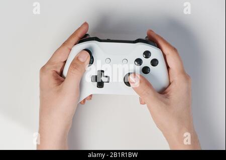 White controller with black buttons in hand above top view Stock Photo