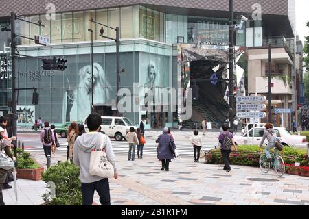 TOKYO, JAPAN - MAY 9, 2012: People shop in Omotesando district in Tokyo. Omotesando is considered one of most important shopping areas in Tokyo, the l Stock Photo